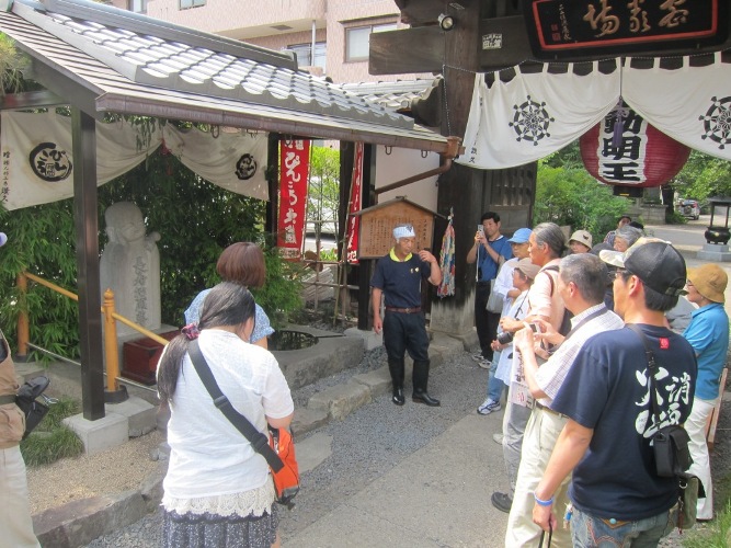 ぴんころ地蔵尊前で説明してくださる市川さん