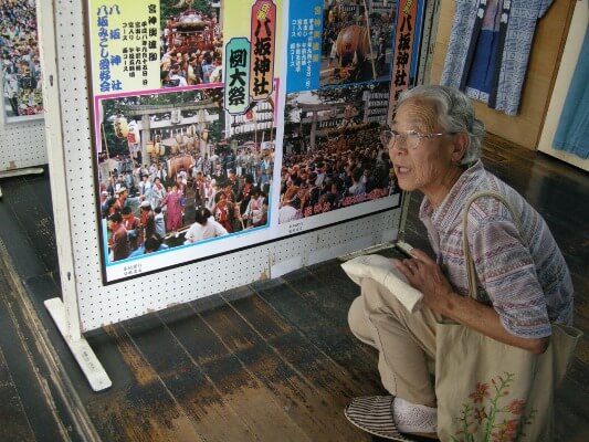 昔のポスターにご主人春雄さんの姿を発見して喜ぶ谷スエさん
